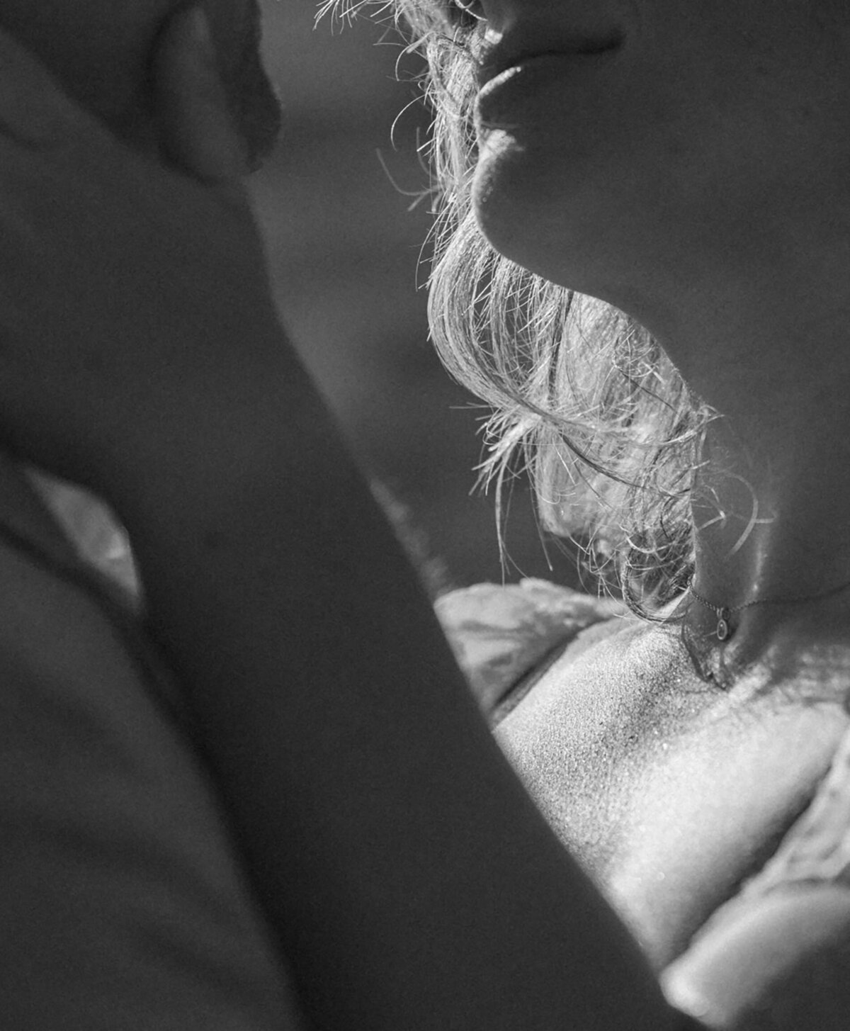 close up of bride touching groom's face as the sun lights up her skin and hair