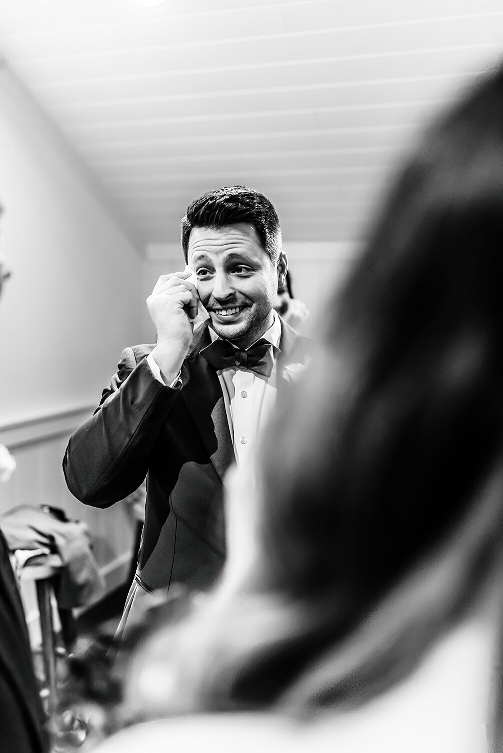 a groom wiping away a tear as he is getting ready