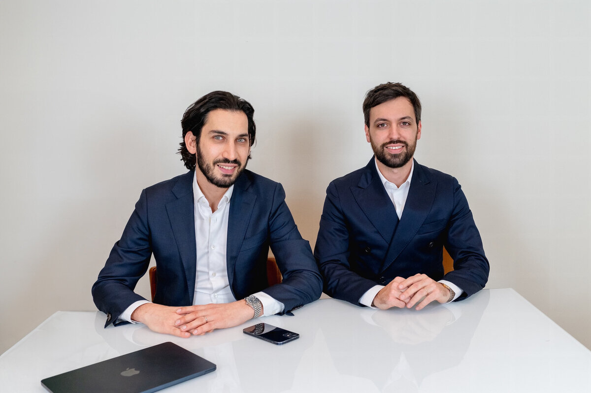 Deux hommes en costume derrière un bureau