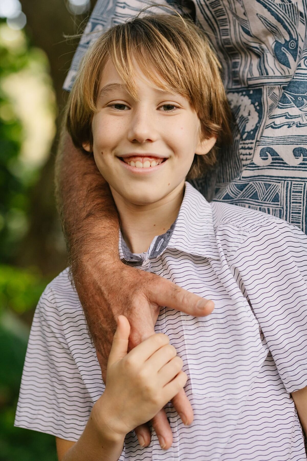 son holding dads hand in closeup portrait