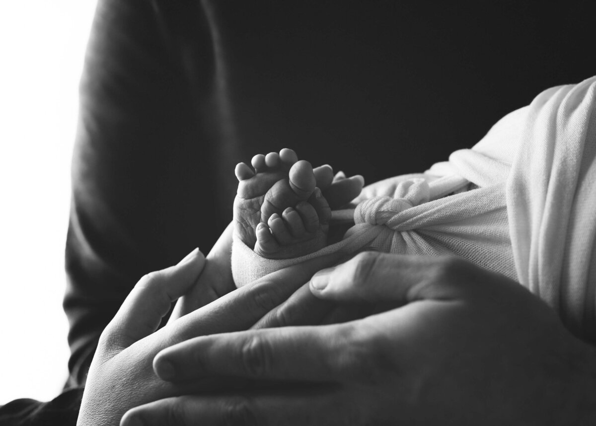 Parents Holding Newborn Baby Feet