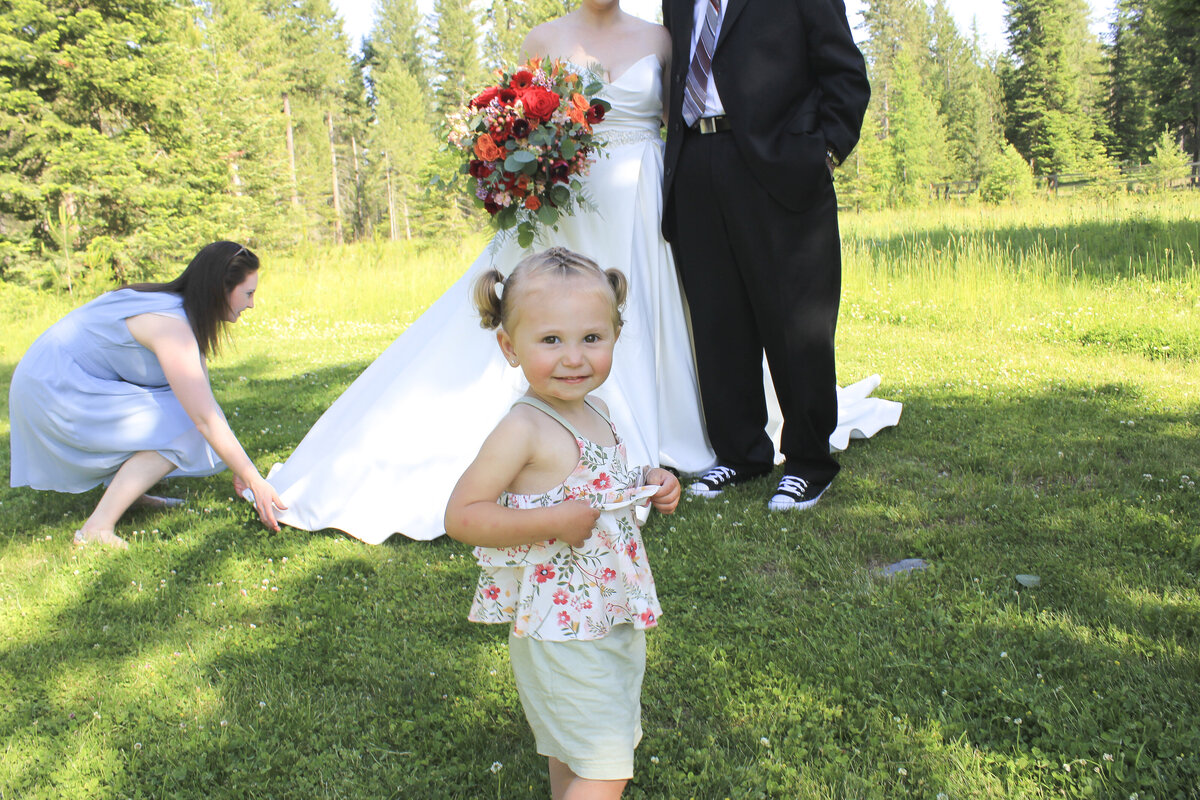 Little girl smiling near bride and groom
