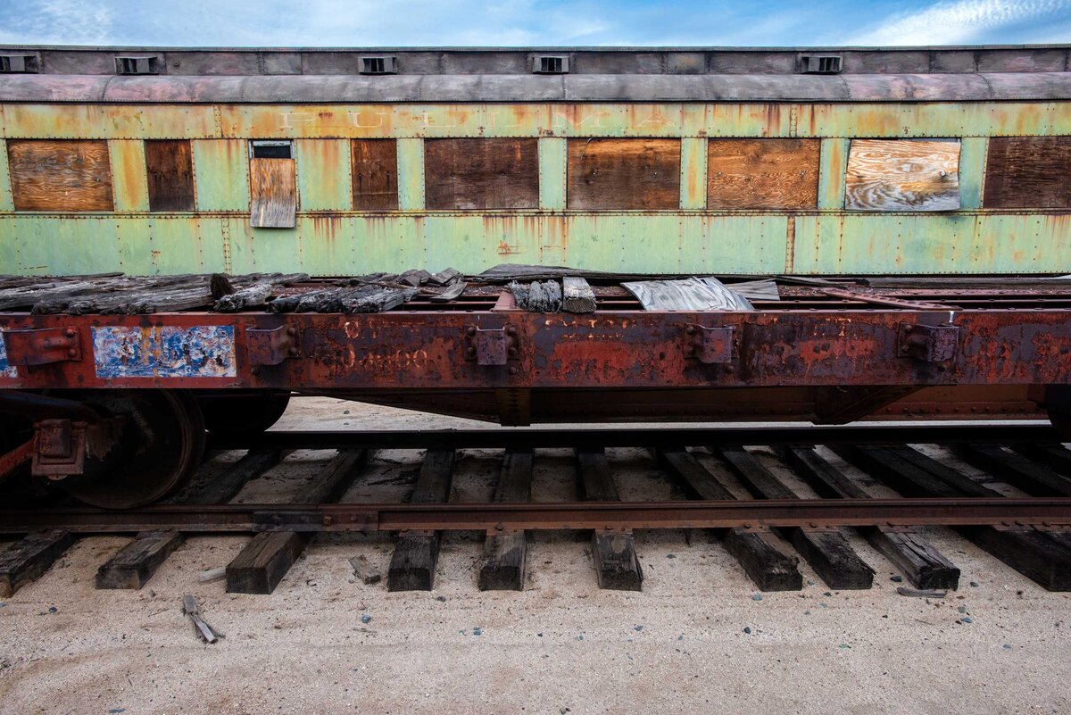 The profile of an old train with green and red rust colors in an artful display of the industrial aging process.