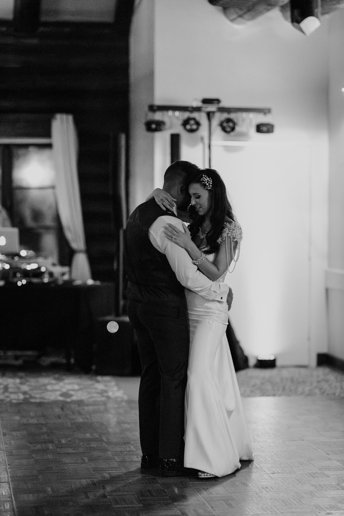 Newly wedded couple hugging and shaeing their first dance alone in the dance floor
