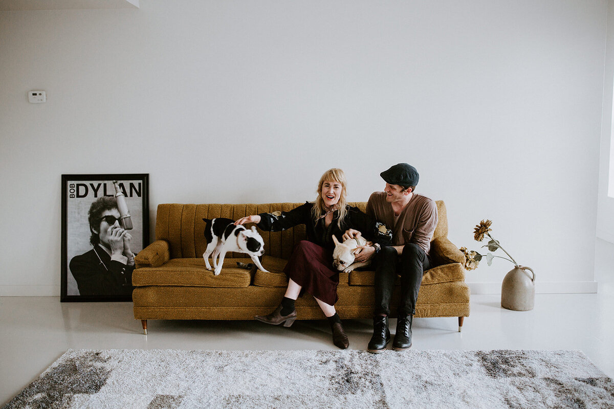 Couple and their dogs sit on a sofa.
