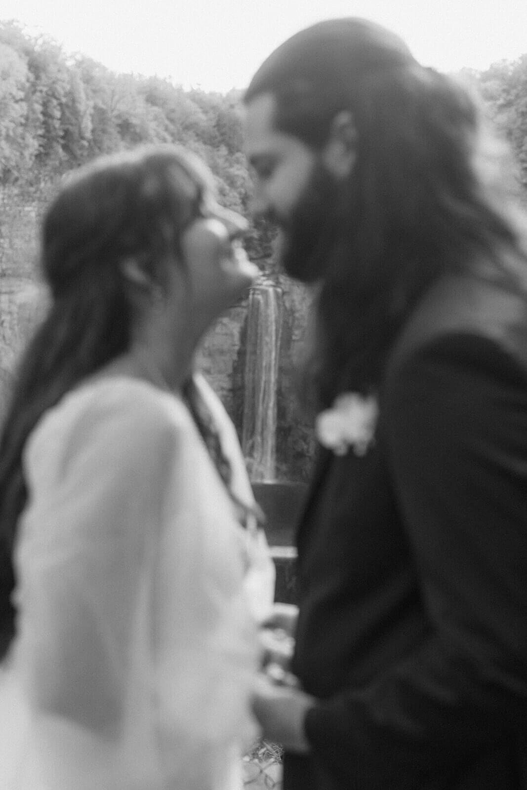 bride and groom noses touching with waterfall in the background