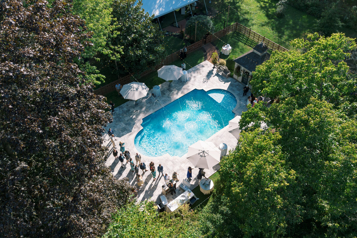 Drone view of guests gathering around the pool during cocktail hour at The Cypress House.