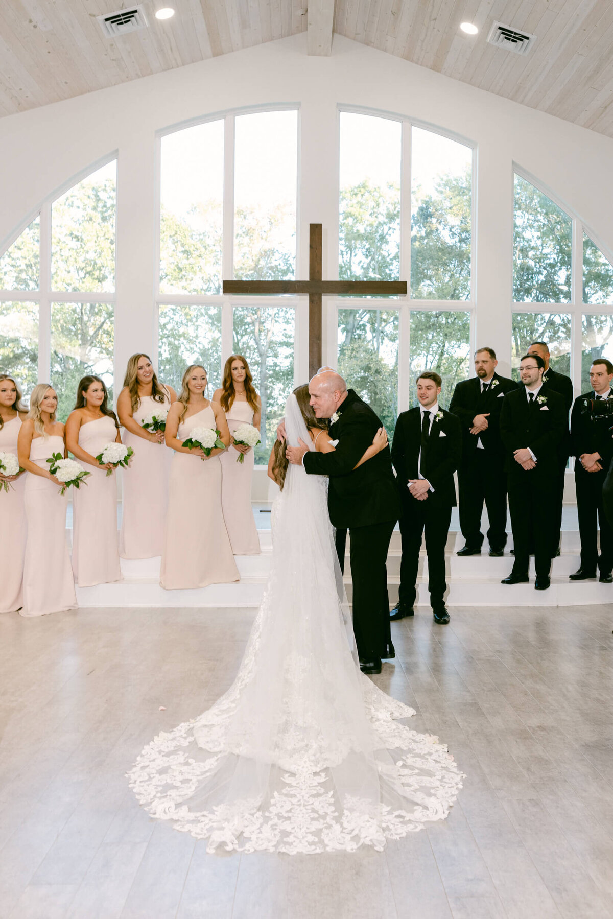 A wedding photo of the bride hugging her dad after he walked her down the aisle
