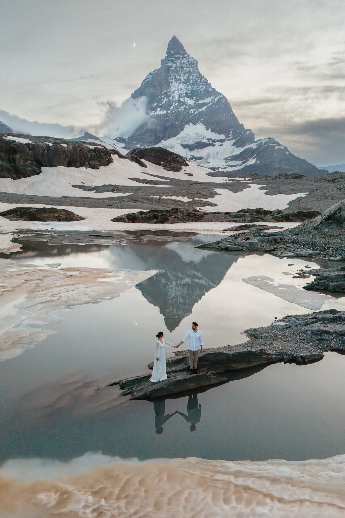 Couple eloping in the Swiss Alps with the Matterhorn reflecting in the water