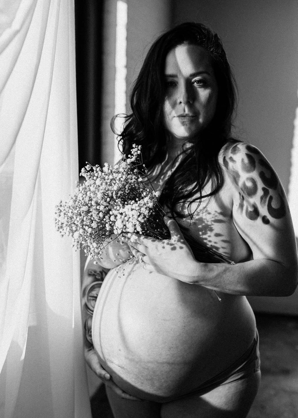 black and white image pregnant woman holding flowers