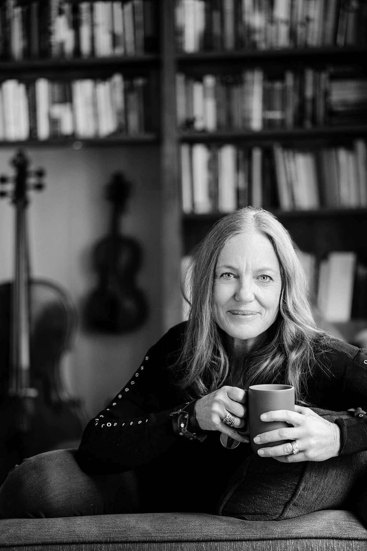 book author holding coffee mug in her living room