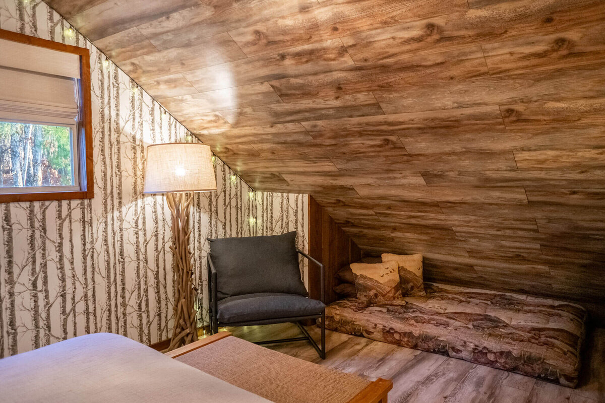 Comfortable reading nook with lamp and daybed inside mountain lodge