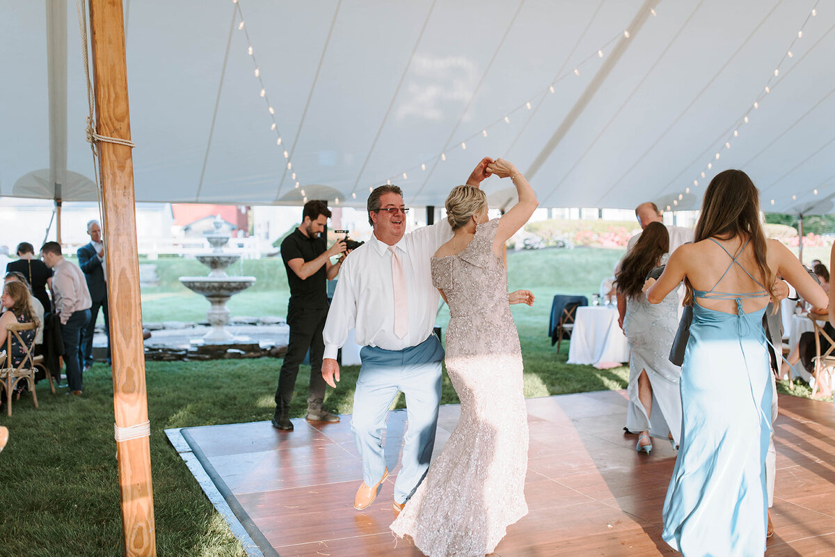 wedding guest dancing under sailcloth tent at upstate new york wedding venue