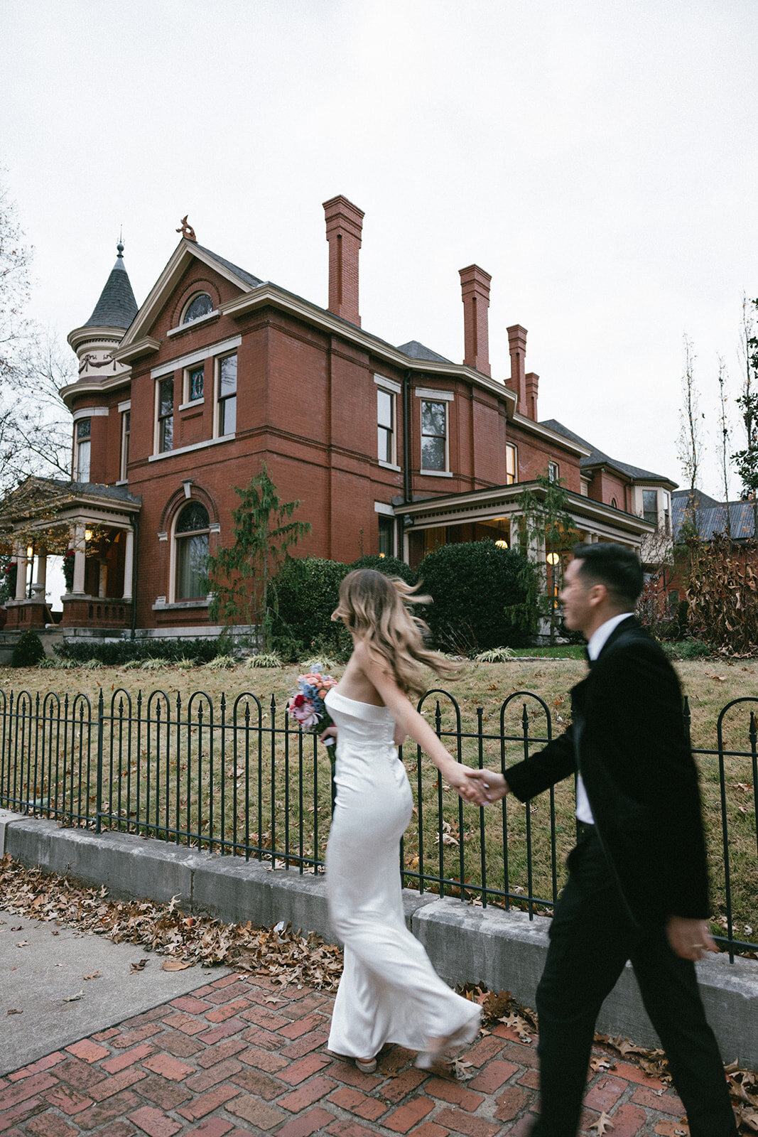 A bride and groom candidly walk down a stone street in East Nashville towards their elopement ceremony site. 