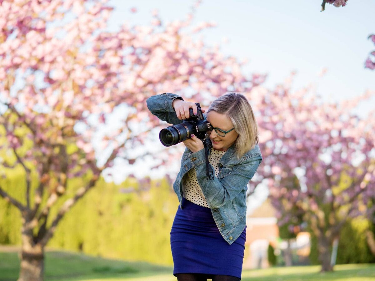 crystal genes photography takes a photo with cherry blossom trees in the background