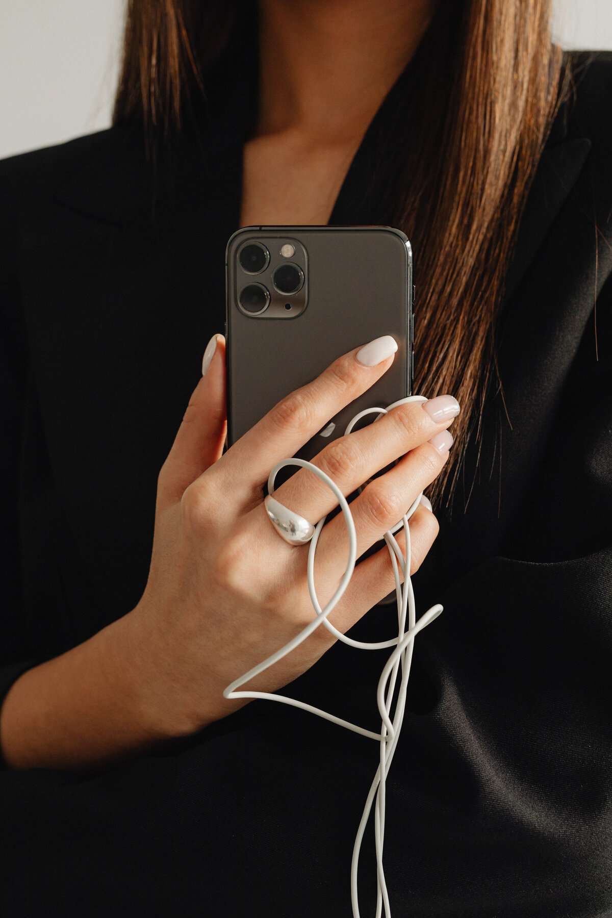 kaboompics_dark-classy-aesthetic-fashion-beautiful-asian-female-entrepreneur-in-black-suit-technology-and-devices-iphone-laptop-airpods-30075