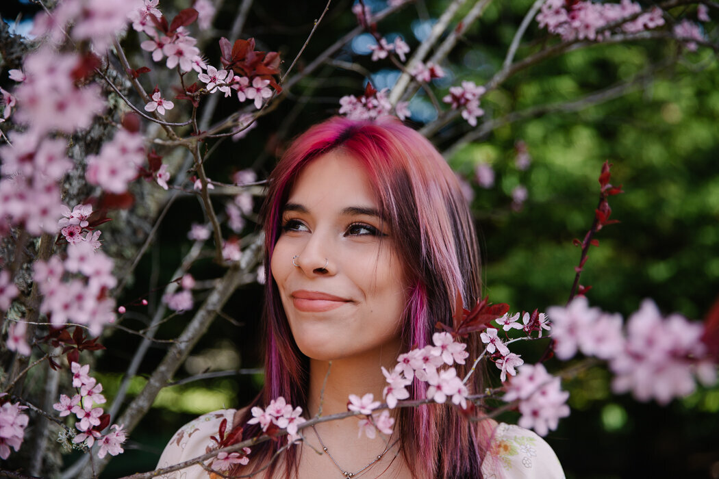 Senior girl smiling with cherry blossoms around her face