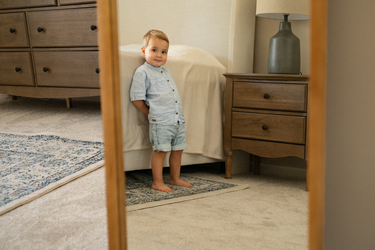 toddler looking in the mirror at the camera