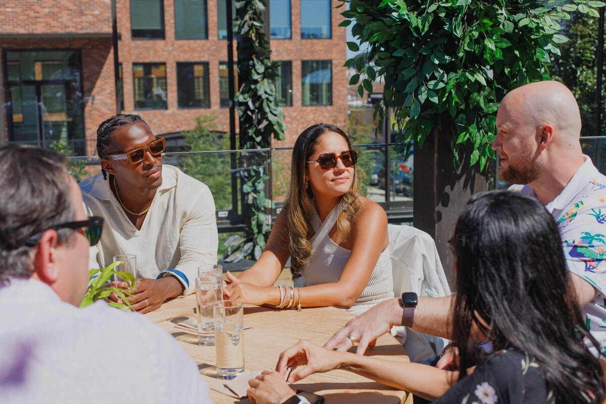 Guests in conversation at an outdoor table.