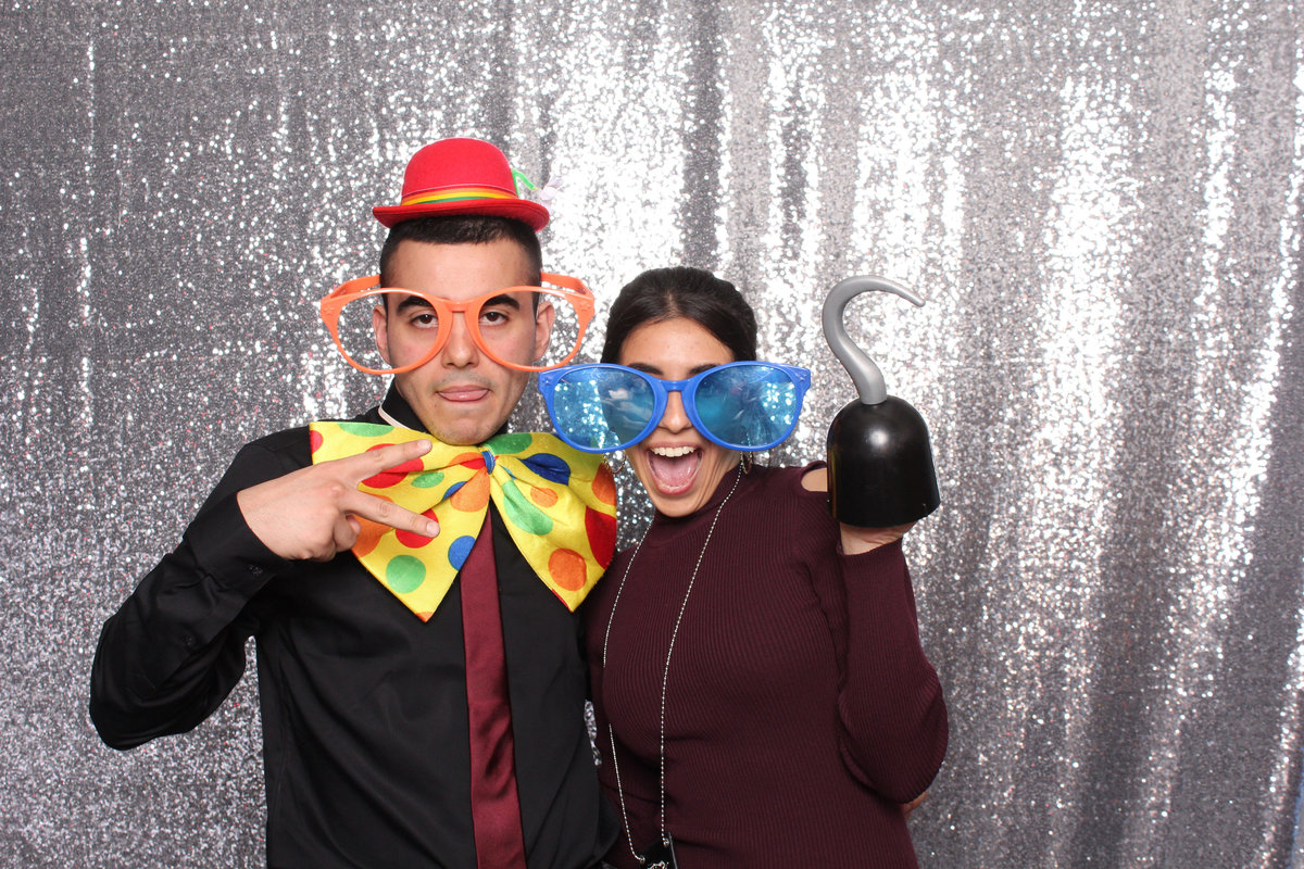 Man and Woman ham it up with props in a photo booth rental