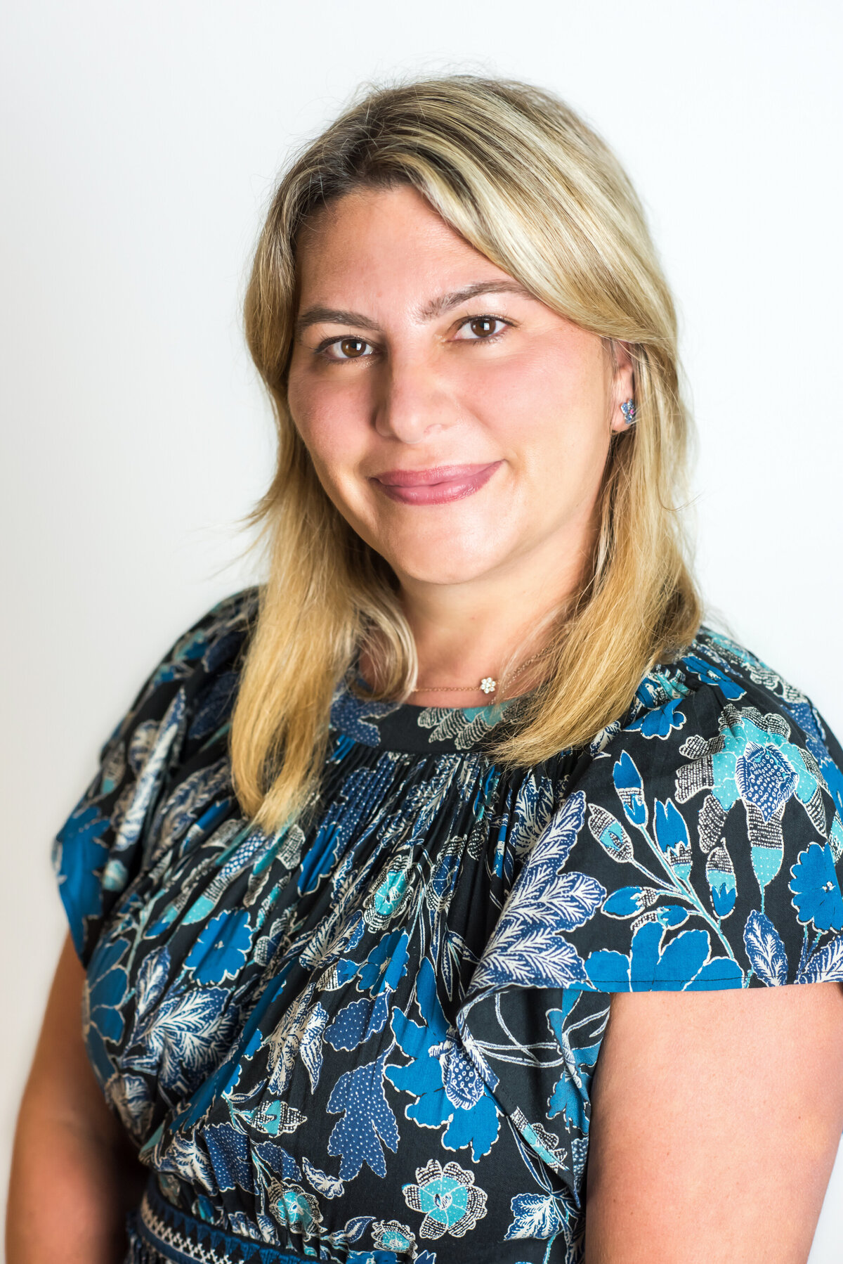 A woman in a floral shirt smiling