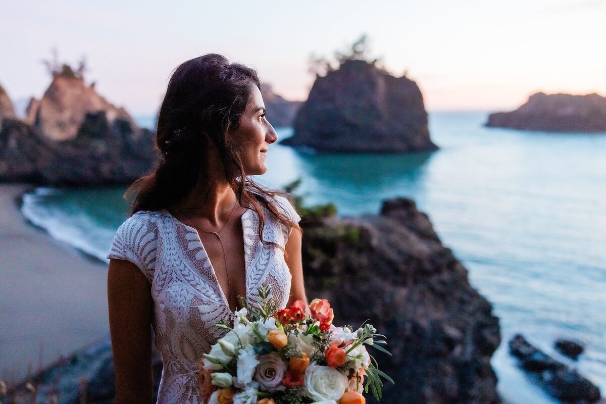 a bride looks out to the sunset.