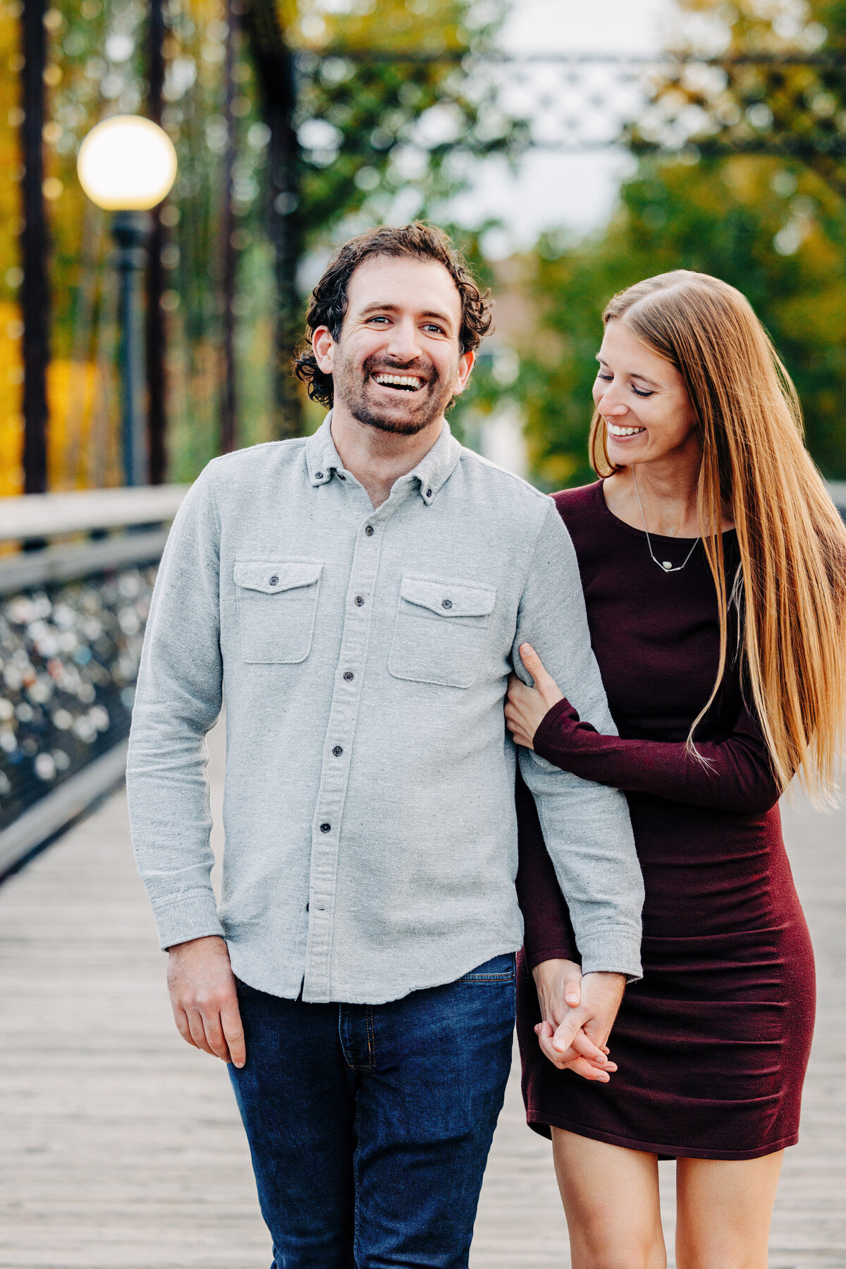 Engagement photo couple walking on Van Buren Footbridge in Missoula