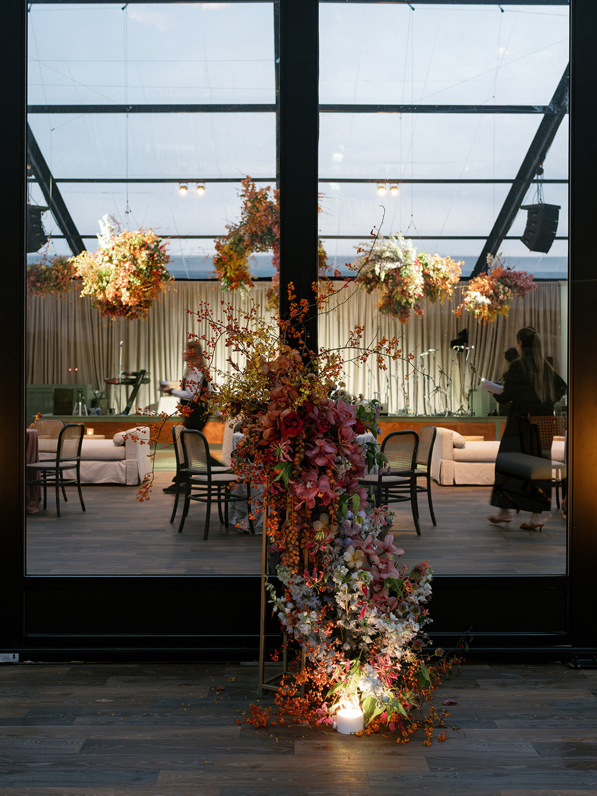 Private home wedding reception with clear top tent and autumnal wedding design. Unique fall wedding color palette with textural coppers, golds, rubies, and lavenders. Curated wedding design with sculptural floral moments, embroidered linens, and custom fabricated bars. Florals highlighted by clustered moments of orchids, mums, ranunculus, tulips, delphinium, and bittersweet. Flower forward wedding floral for fall wedding reception. Design by Rosemary & Finch Floral Design in Nashville, TN.