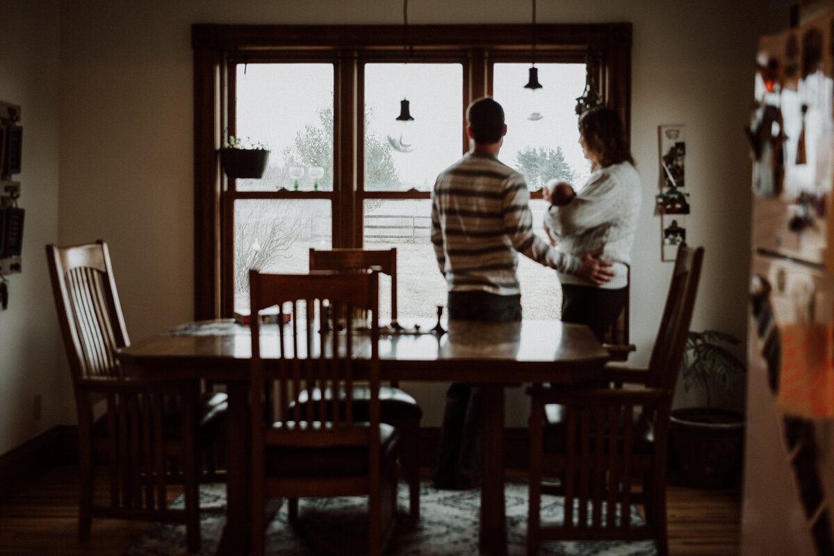 Parents holding newborn baby during in-home lifestyle newborn session in the Twin Cities.