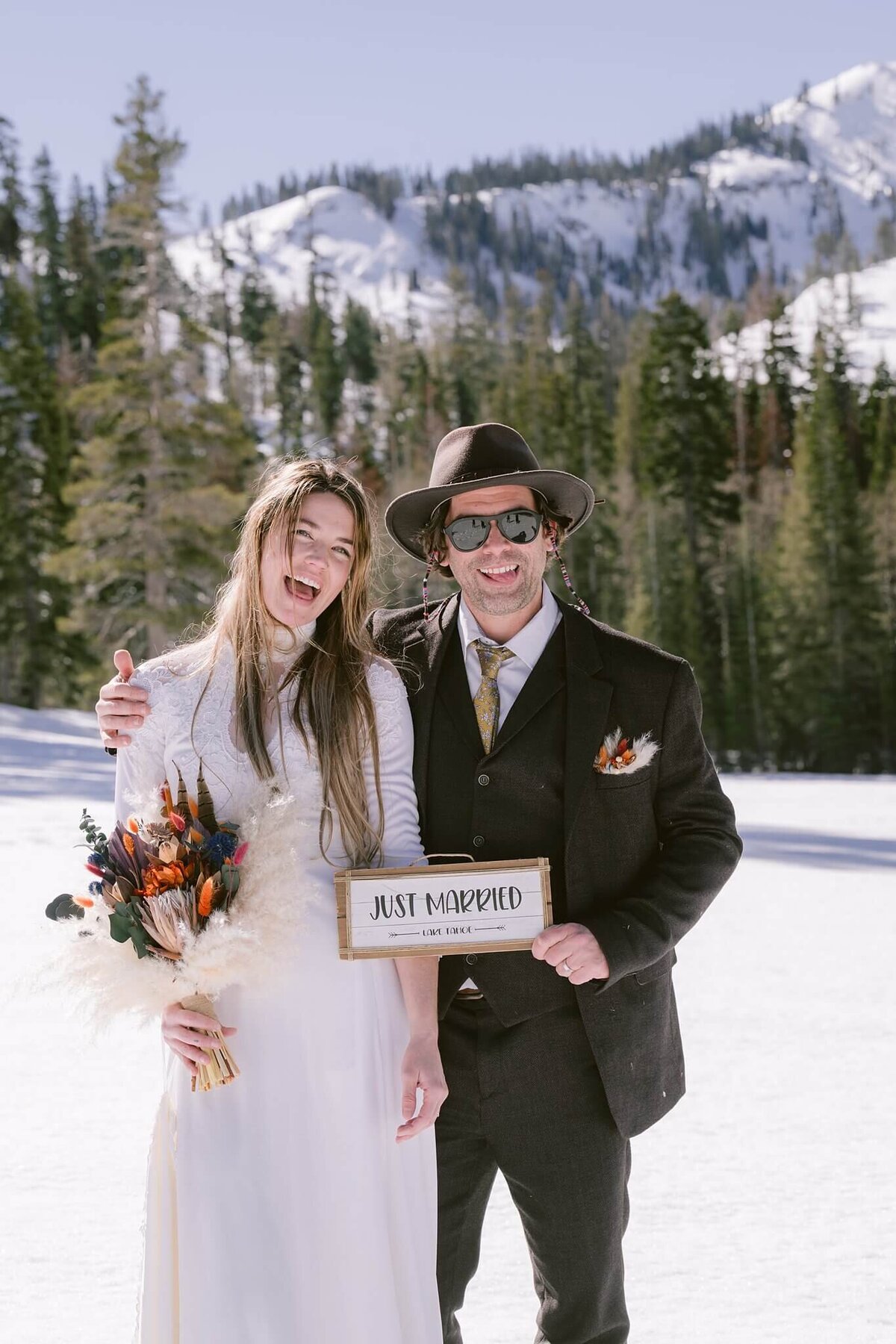 Bride and Groom holding a just married sign after ceremony in Alpine meadows winter elopement