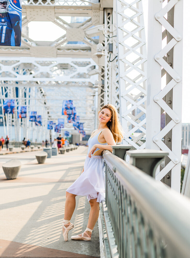 Dancer casually leaning on the railing of a bridge