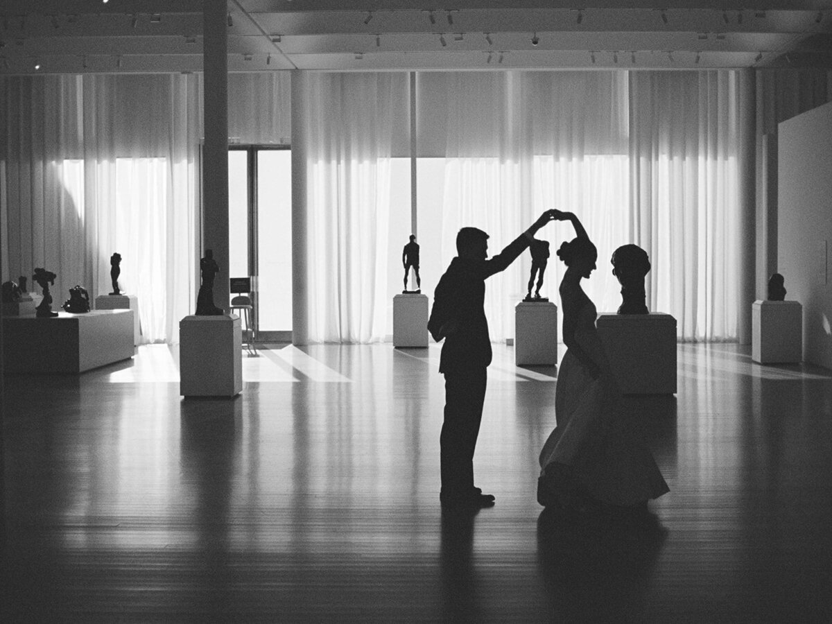 Wedding rings sitting in small white ring dish next to another dish with a branch laid across