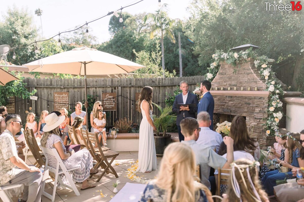 Officiant reads to the Bride and Groom at the backyard wedding altar