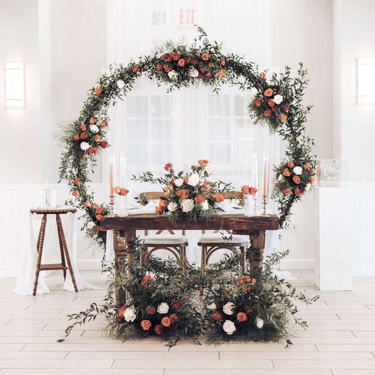 flower arch and bouquets of orange and white roses