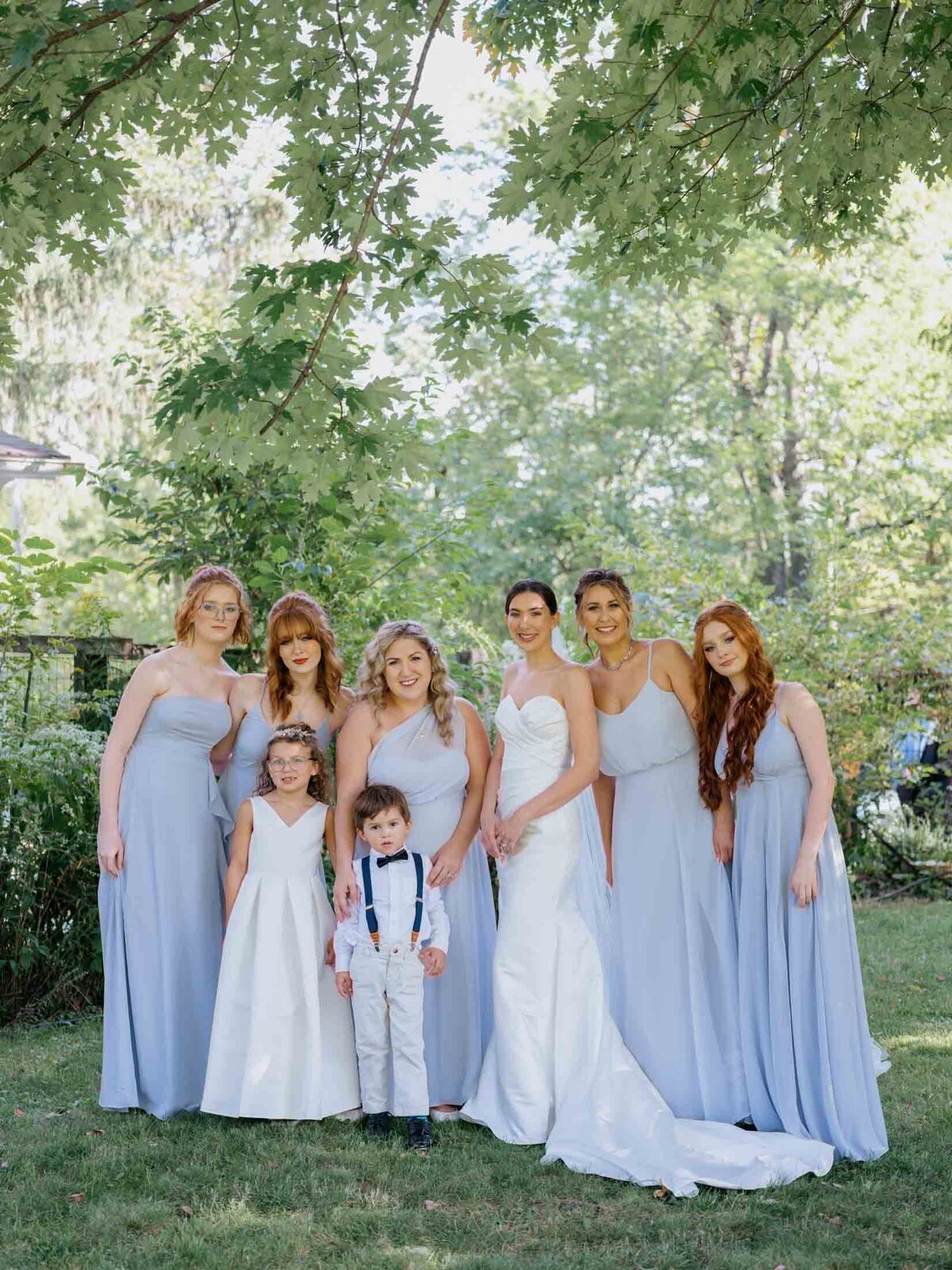 Bride in Maggie Sottero gown with bridesmaids in blue Birdy Grey dresses.
