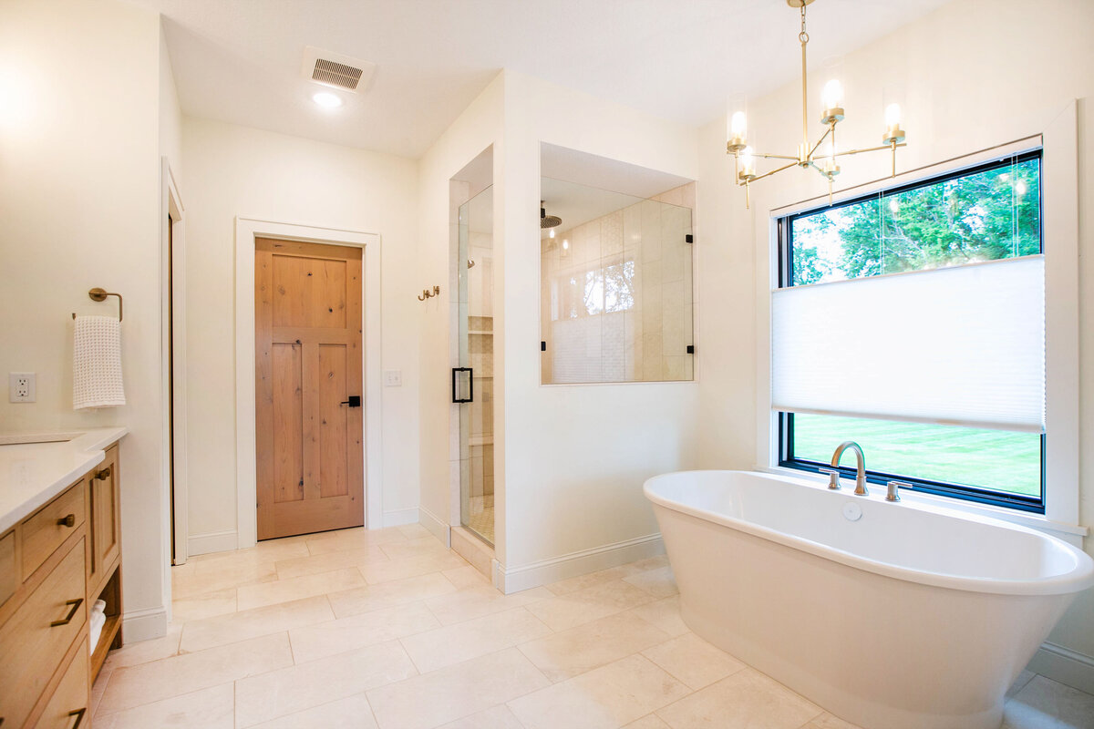 Custom primary bathroom with freestanding tub, tile floors, and double vanity designed by Cornerstone Custom Builds.