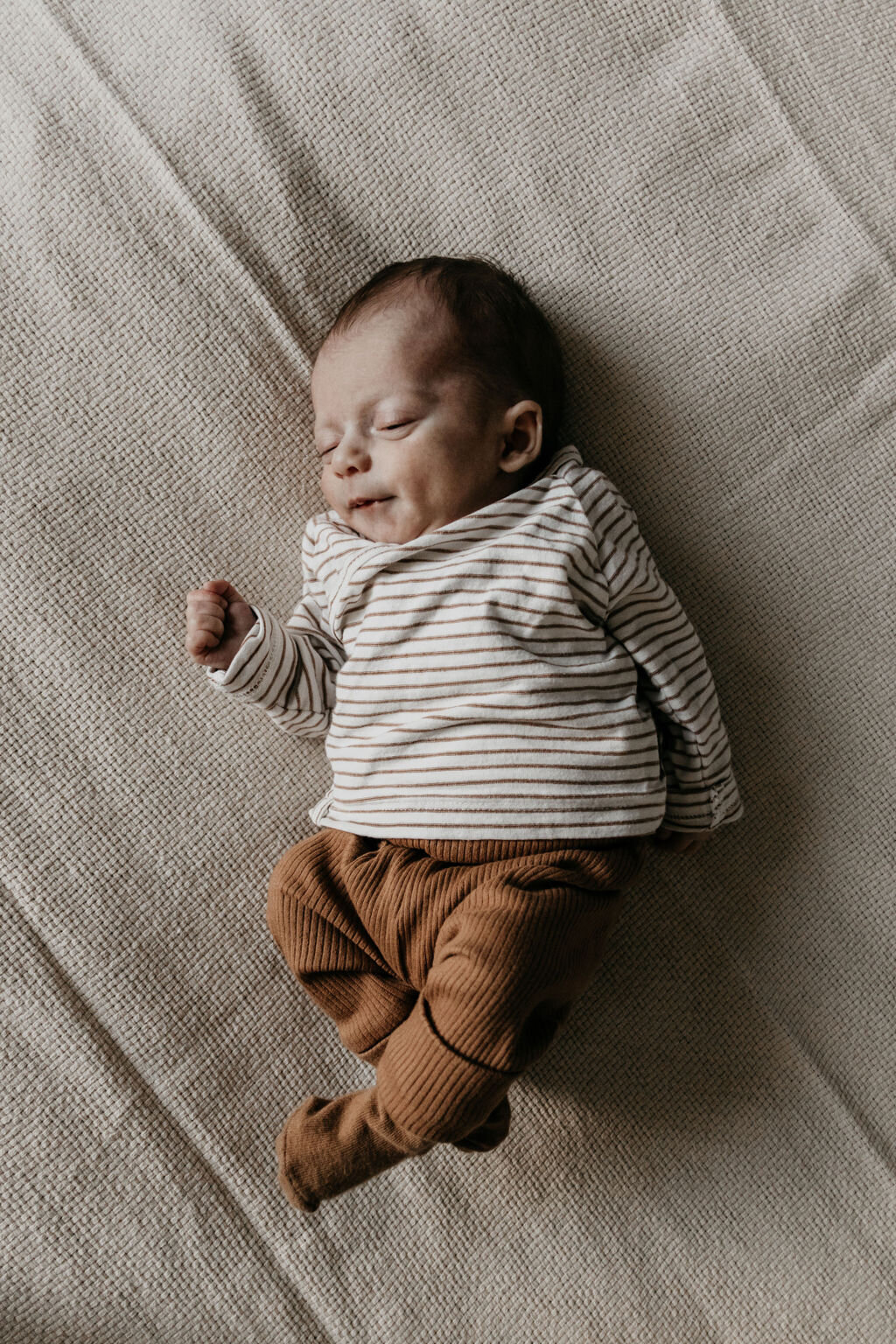 Newborn baby liggend op bed tijdens de newbornshoot in Noord-Nederland