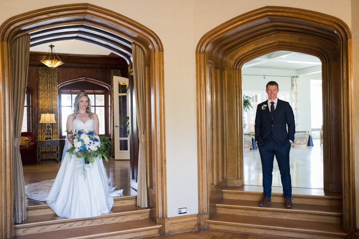 A bride and groom stand in two separate doorways, not seeing each other on their wedding day.