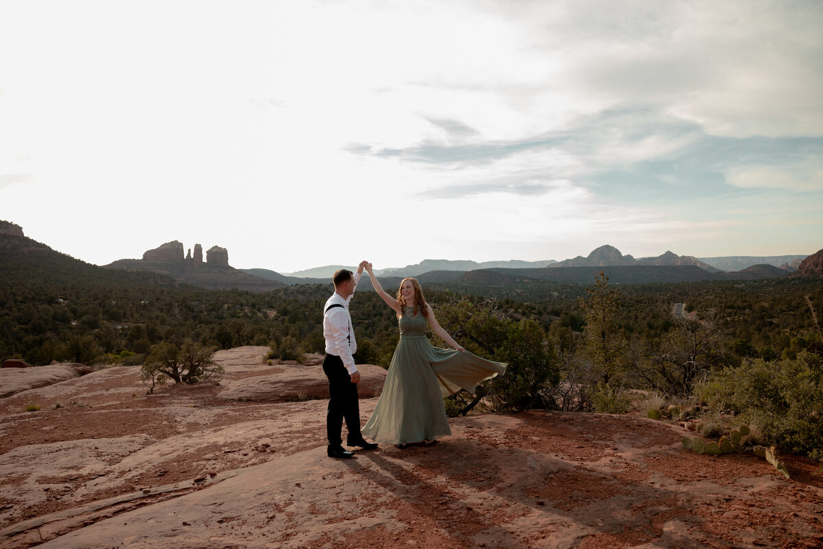 Couple standing against red rock backdrop during Sedona engagement session