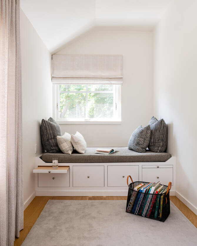 Custom daybed with white cabinets, a grey cushion, Walter G textiles for window treatments, and simple white walls in a modern new construction home in Hingham.