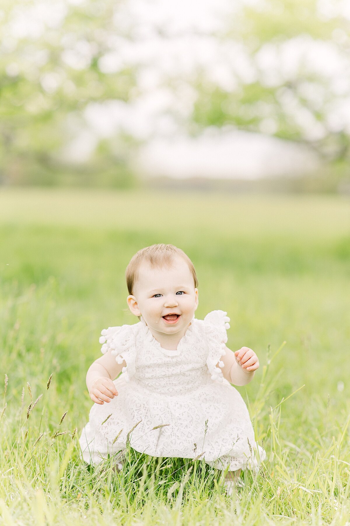 girl sits in grass duirng spring family photo session with Sara Sniderman Photography in Natick Massachusetts