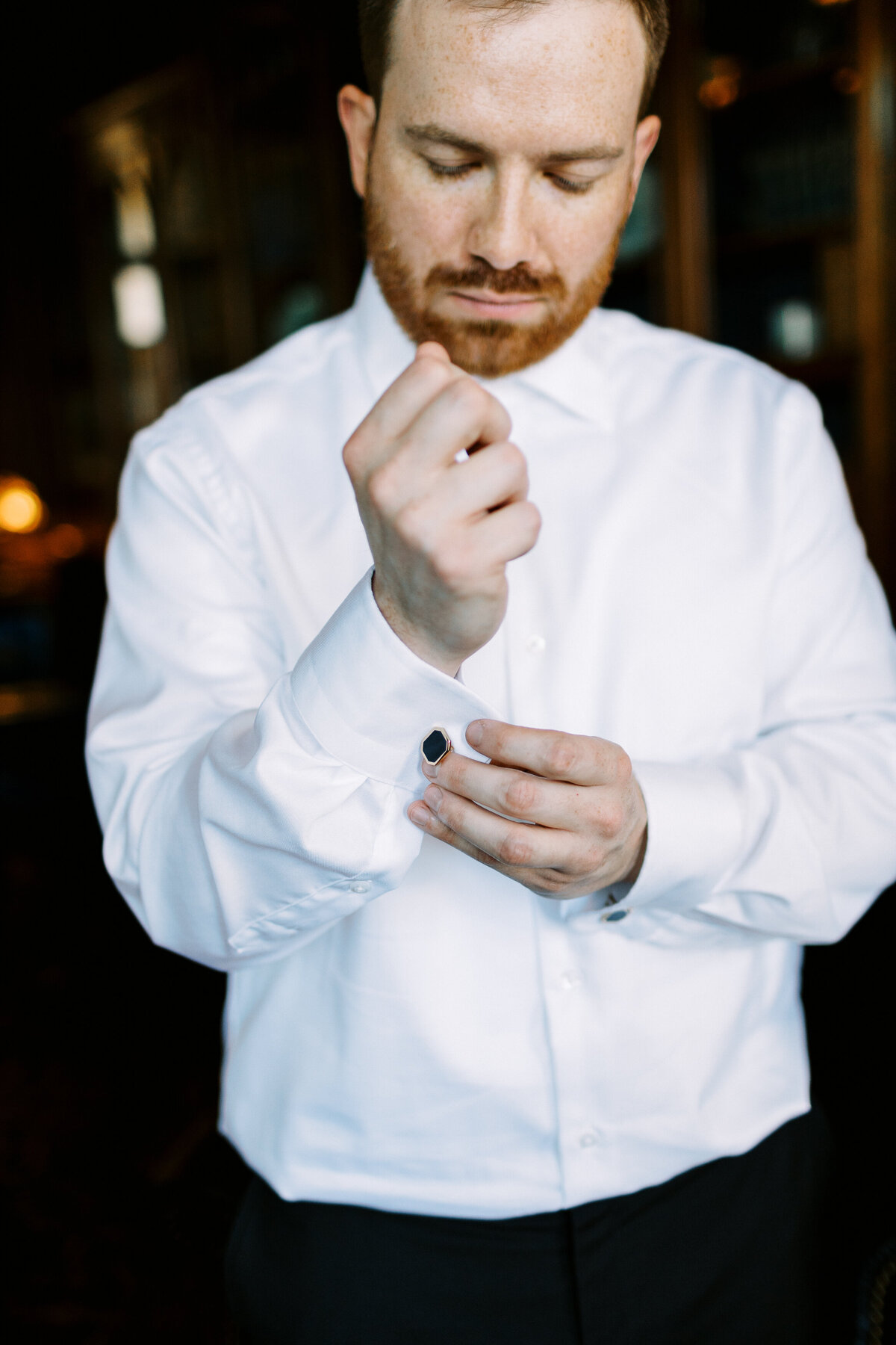 groom putting in his cufflinks