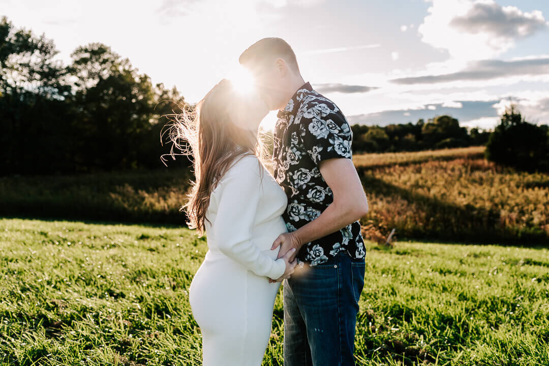 A couple kissing passionately with the sun