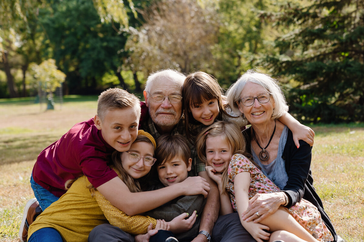 Grandkids hugging their grandparents and smiling