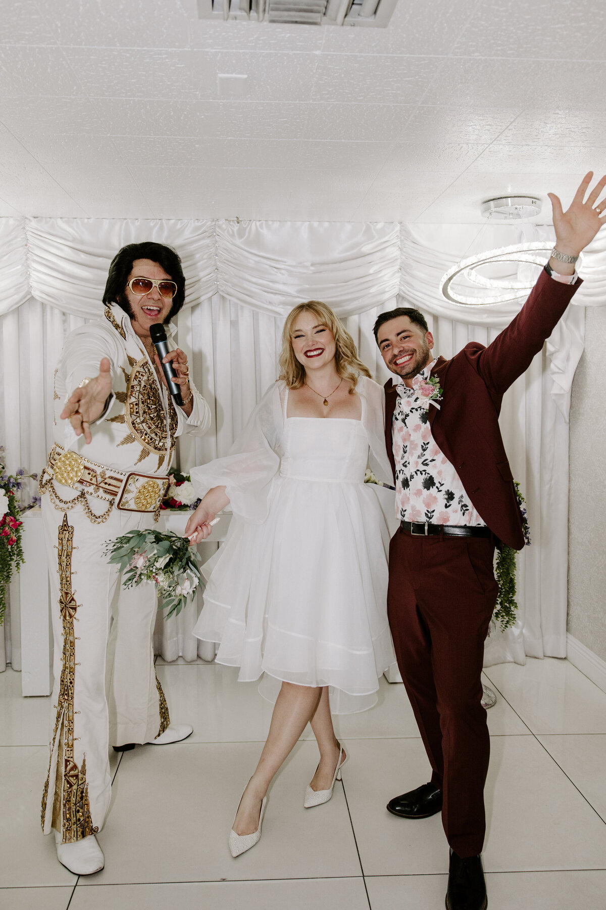 A couple poses on their elopement day with an Elvis impersonator.