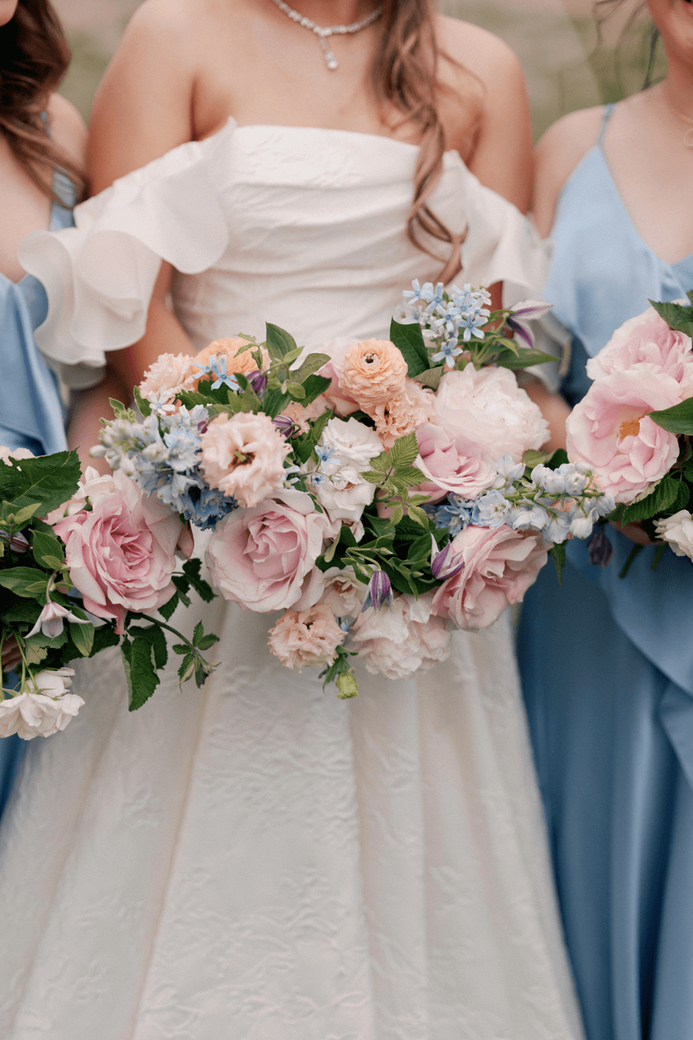 Close-up of the bride’s pastel bouquet with garden roses, ranunculus, and delphinium at a summer wedding at Moonlight Basin.