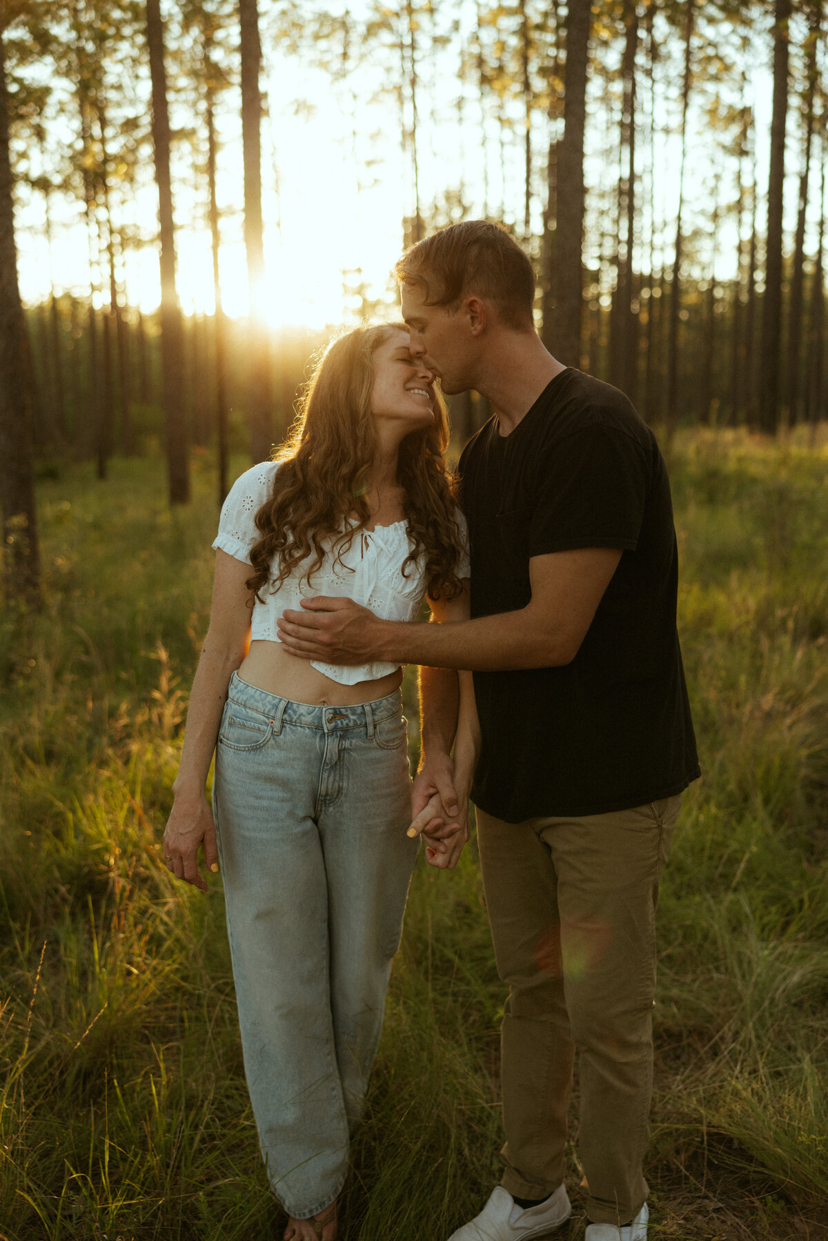 Couple posing for portraits in a forest.