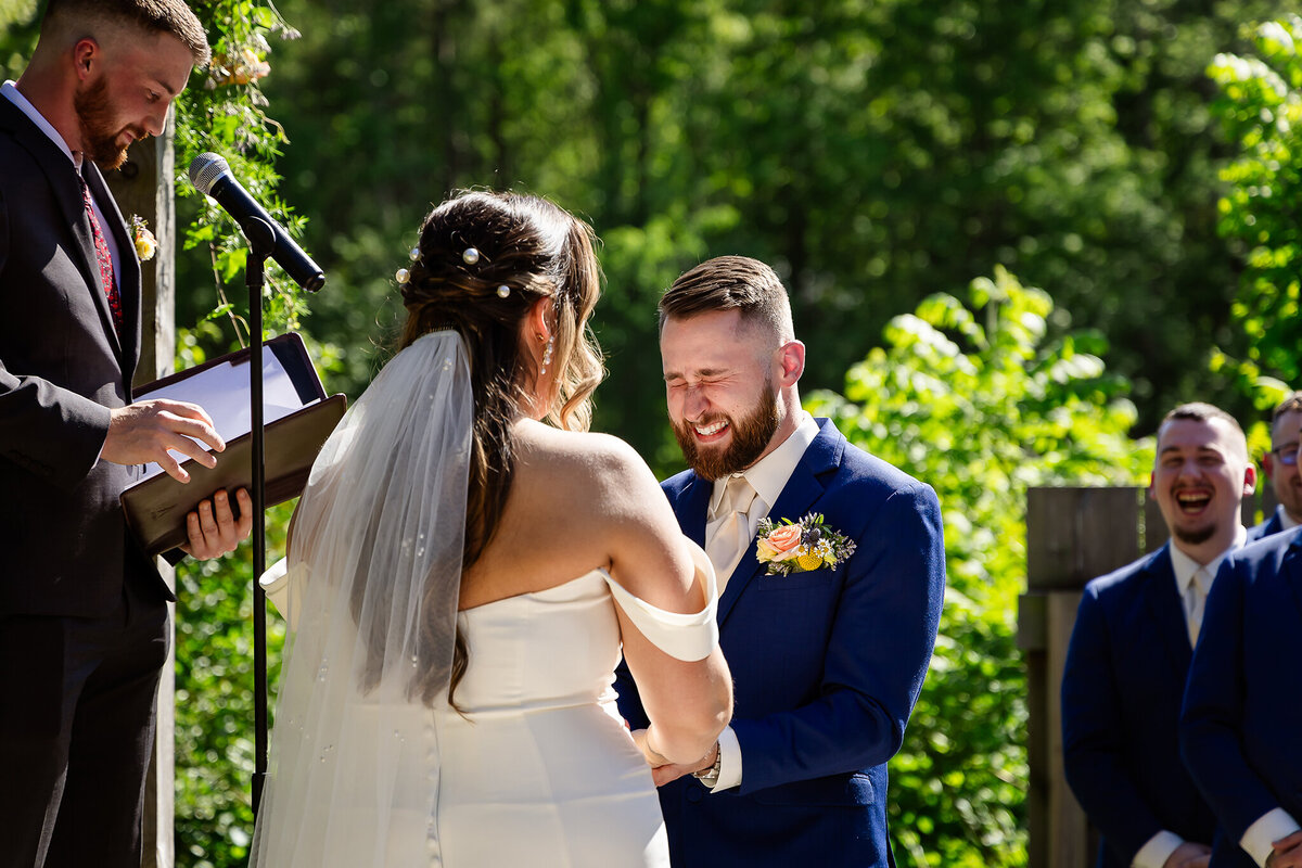 Groom laughing during spring ceremony at nh wedding venue