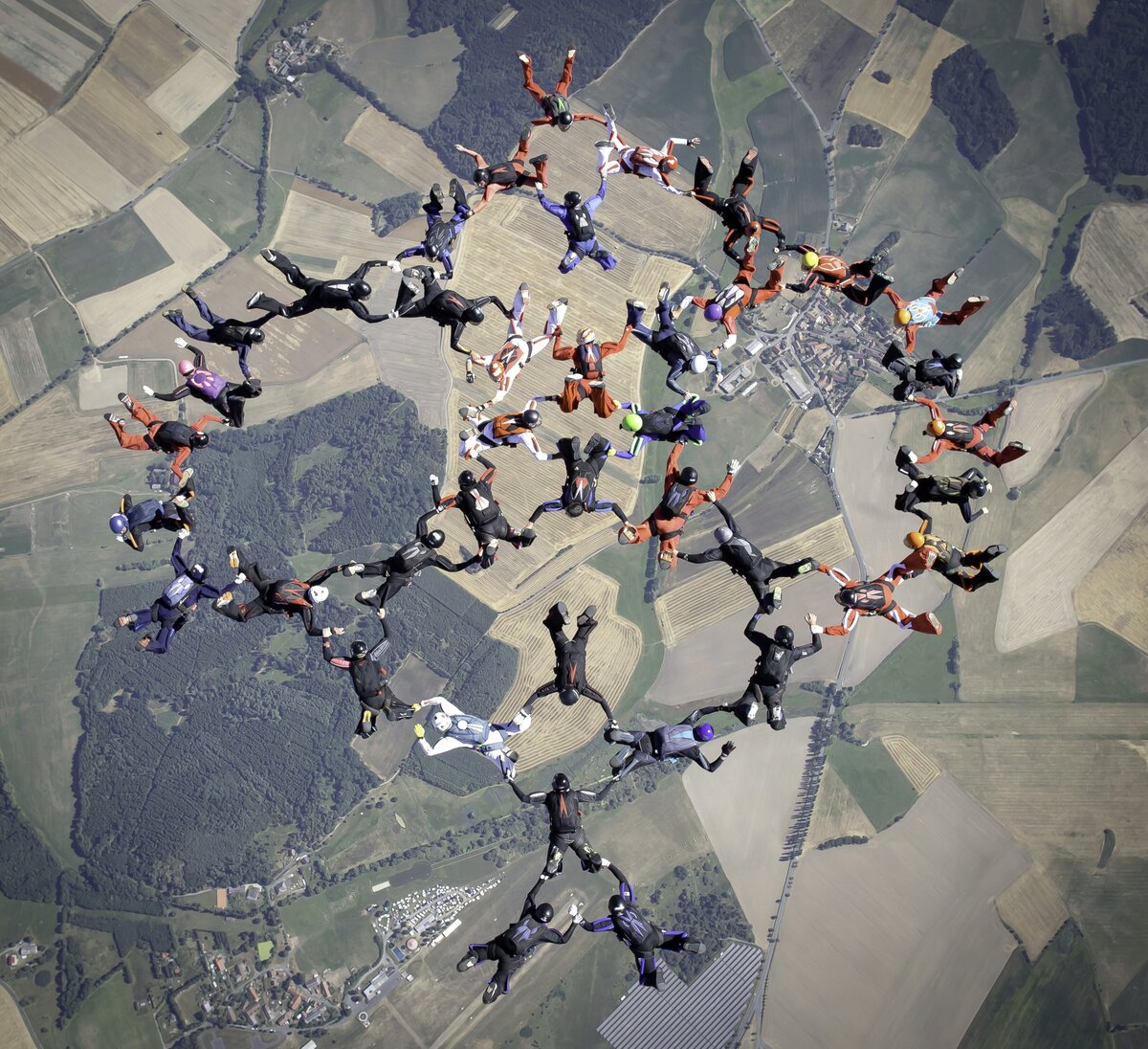 Das Bild zeigt eine Formation von Fallschirmspringern über dem Sprungplatz Skydive Pink Klatovy