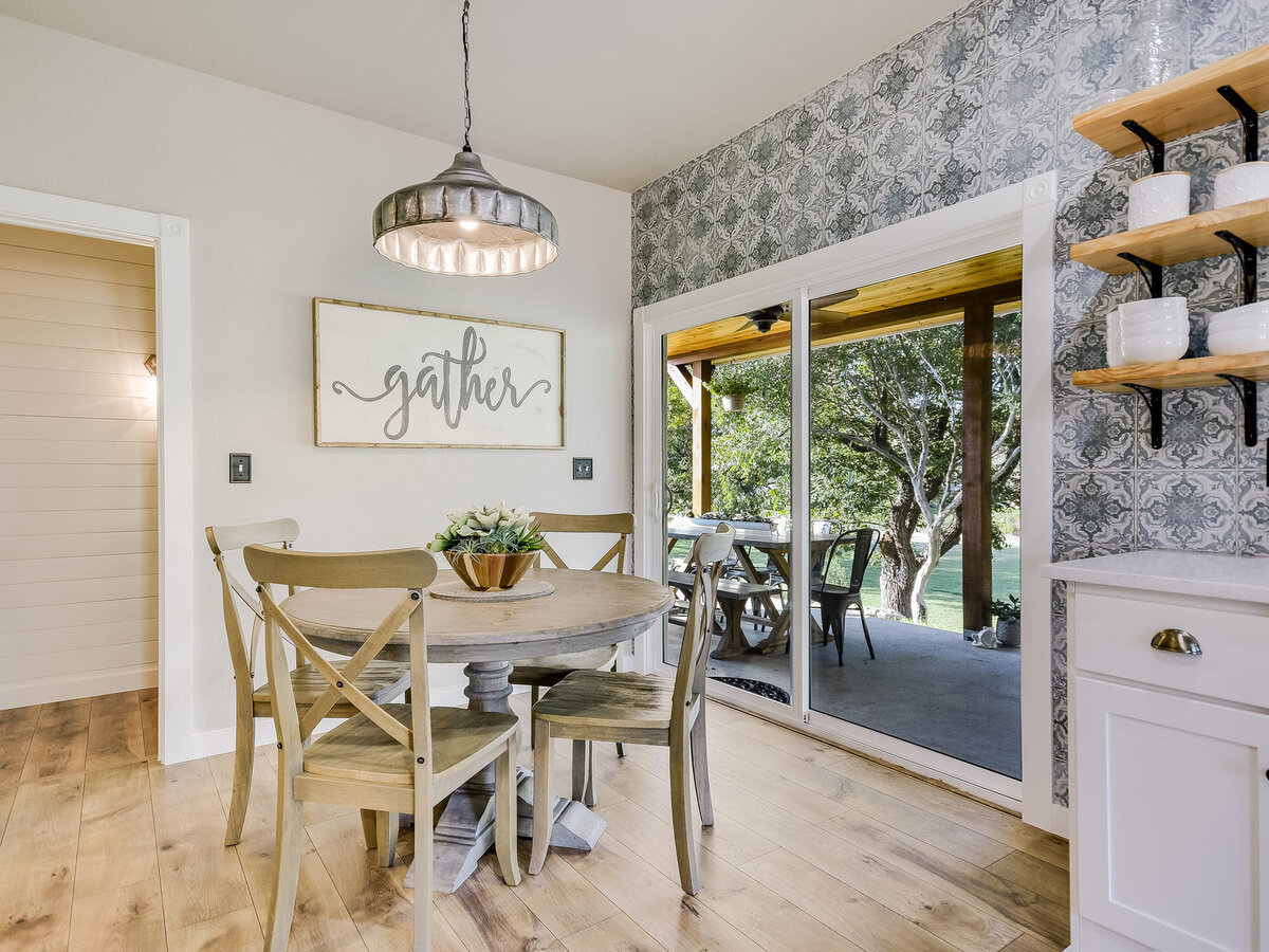 Small kitchen dining area with hanging lamps and decorative wallpaper